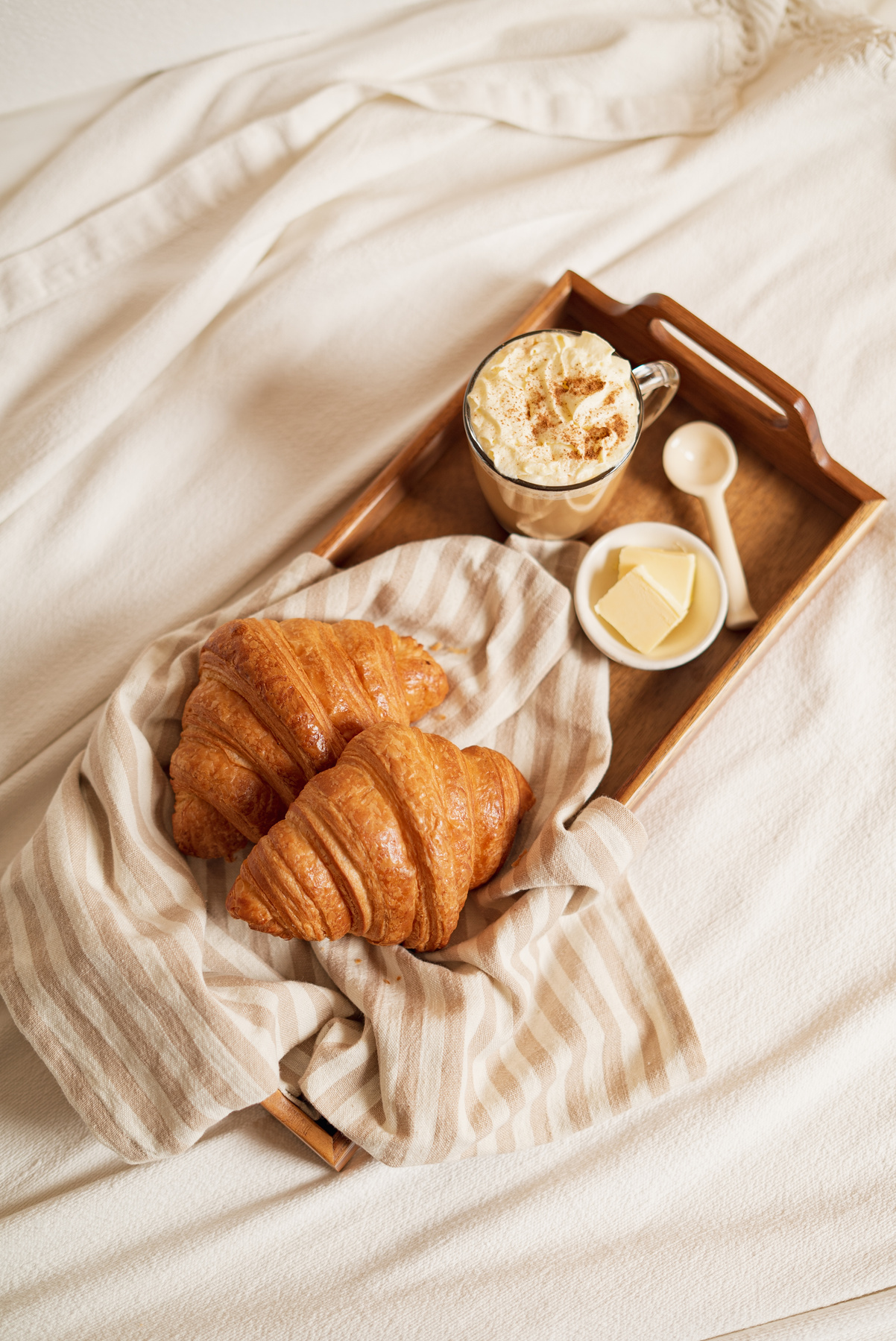 Top View of Tray with Coffee and Croissants on Bed